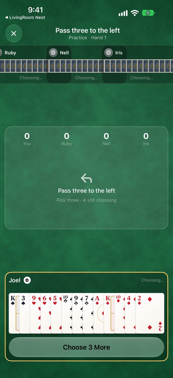 The passing: everyone's score along the top, an arrow showing the cards go left, and thirteen cards in your hand.